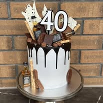 White 40th birthday drip cake with chocolate drip, mini Jack Daniels bottles, Tim Tams and gold number topper